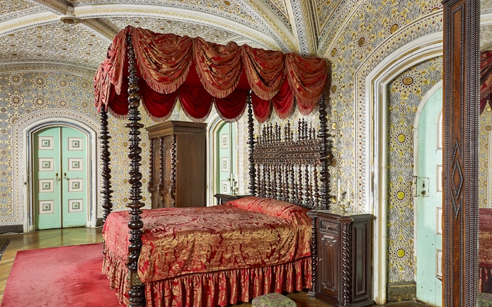 Bedroom of Ferdinand II in Royal Apartments, Pena Palace, featuring ornate bed and intricate wall designs.