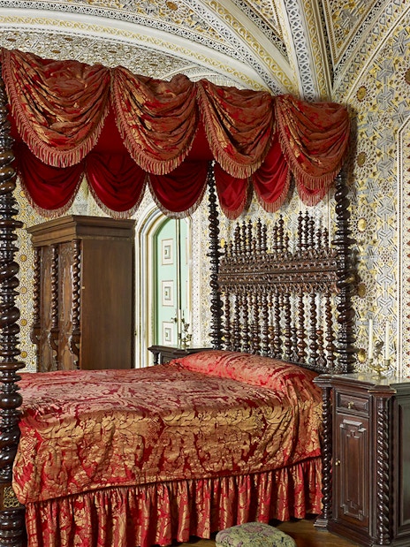 Bedroom of Ferdinand II in Royal Apartments, Pena Palace, featuring ornate bed and intricate wall designs.