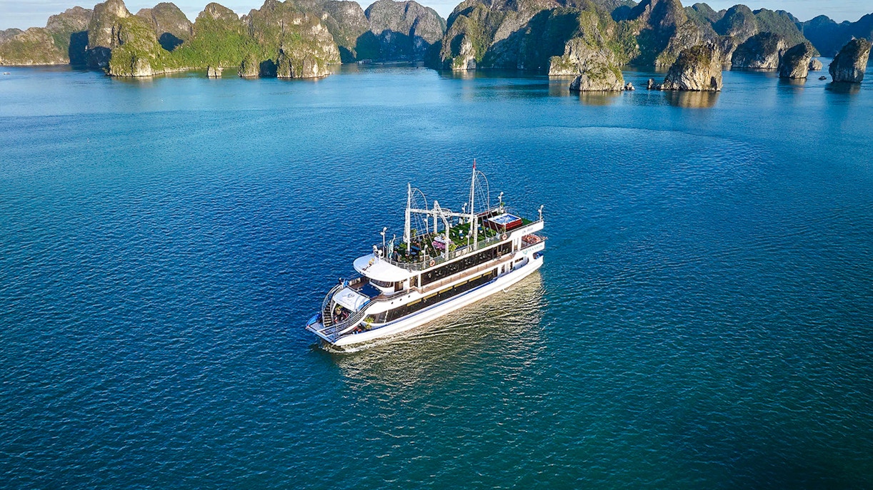 Tour boat sailing in Ha Long Bay, Vietnam, with limestone islands in the background.