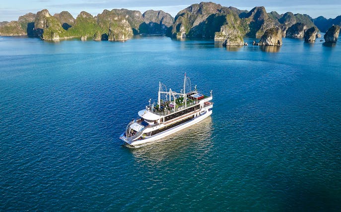 Tour boat sailing in Ha Long Bay, Vietnam, with limestone islands in the background.