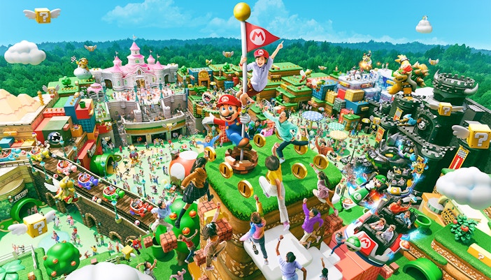Visitors on a group tour at Universal Studios Japan with iconic attractions in the background.
