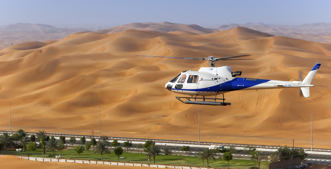 A helicopter flies over Dubai's desert