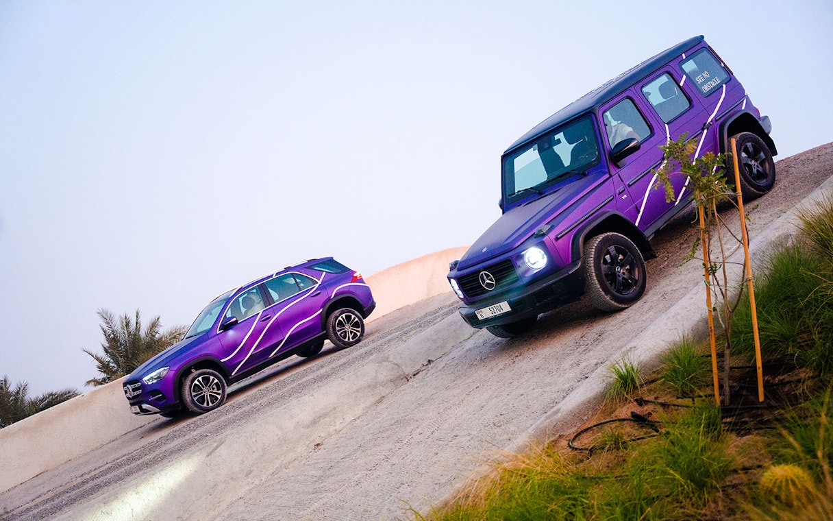 Mercedes-Benz SUVs on a steep incline during off-road experience in Dubai.