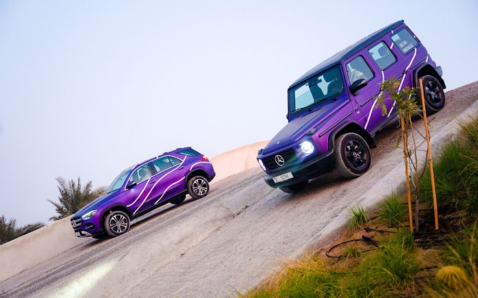 Mercedes-Benz SUVs on a steep incline during off-road experience in Dubai.