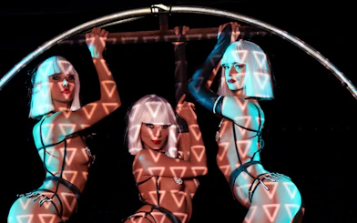 Performers at Crazy Horse Show in Paris with geometric light projections.