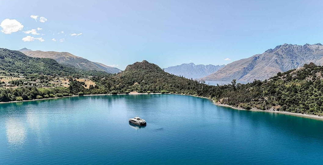 Cruise boat on Lake Wakatipu with mountain backdrop, Queenstown, New Zealand.