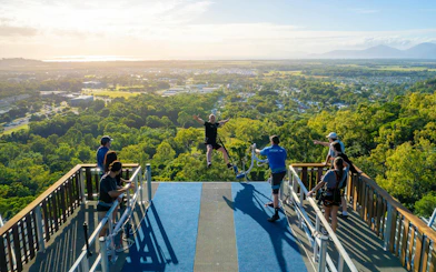 Visitor bungee jumping from Skypark Cairns platform at sunrise with scenic view.