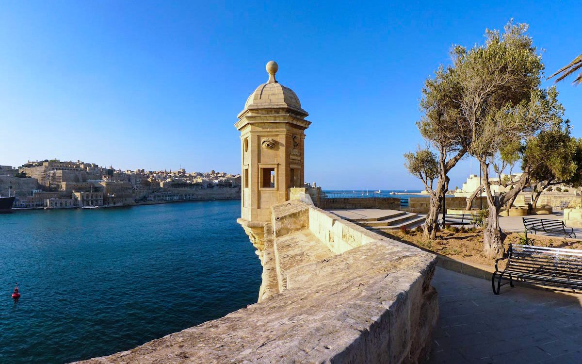 Stone watchtower overlooking the Grand Harbour in Valletta, Malta, with cityscape and sea views.