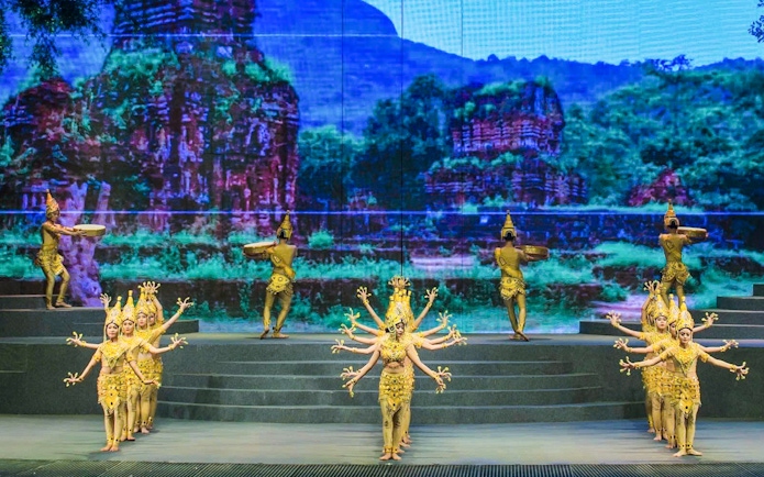 Performers in traditional costumes at Charming Danang Show, Da Nang, with a backdrop of ancient ruins.