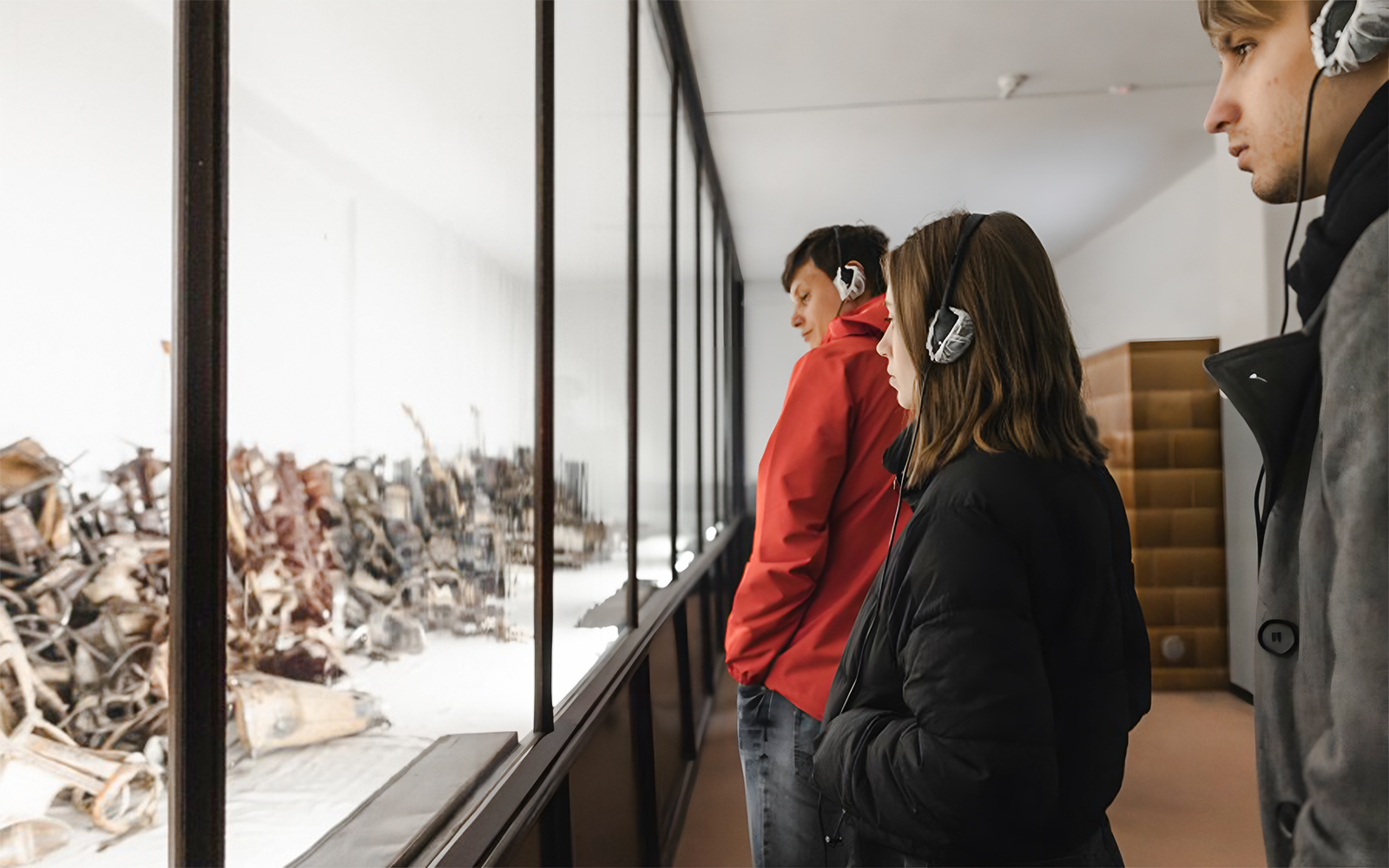 Visitors with audio guides at Auschwitz-Birkenau Memorial and Museum exhibit.