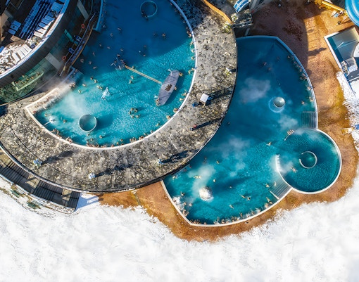 Aerial view of Chochołowska Baths in Zakopane with surrounding mountains.
