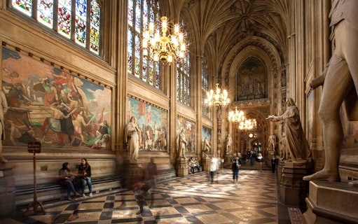 Houses of Parliament interior with statues and stained glass windows, part of guided tour.