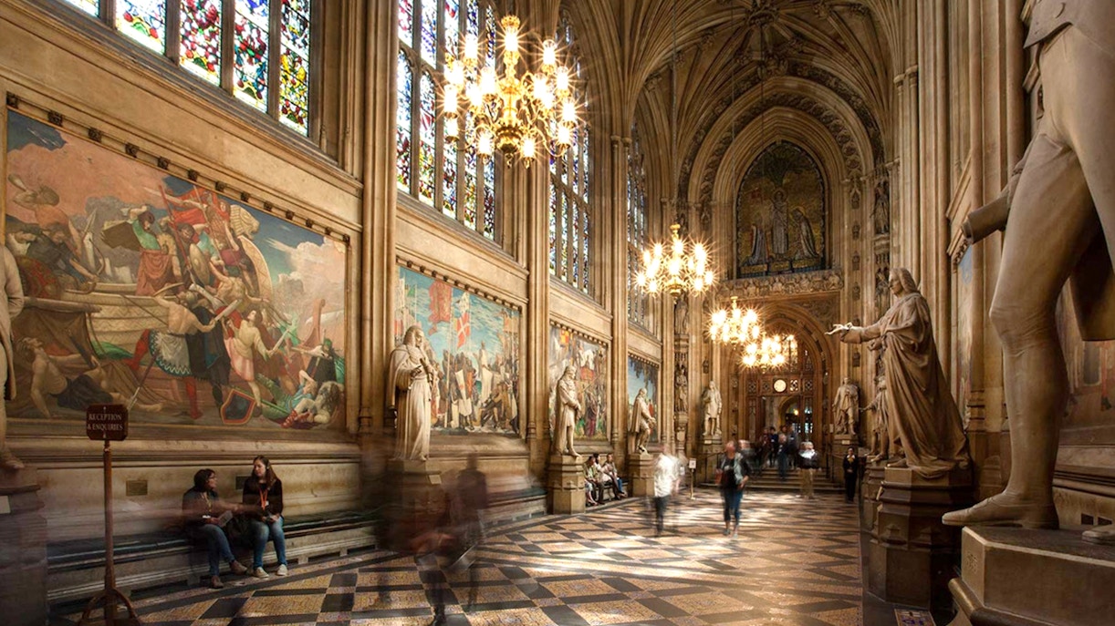 Houses of Parliament interior with statues and stained glass windows, part of guided tour.