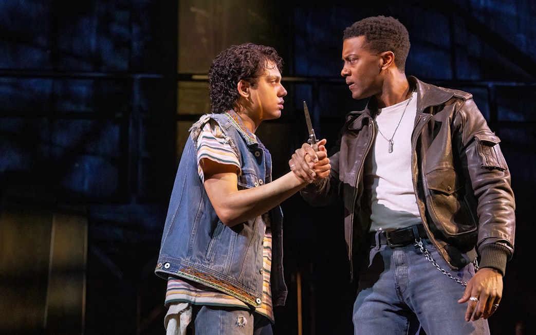 Two actors in a tense scene from "The Outsiders" stage production.