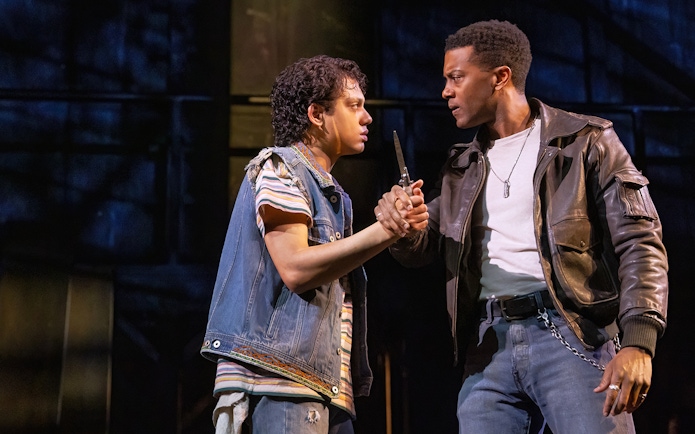 Two actors in a tense scene from "The Outsiders" stage production.