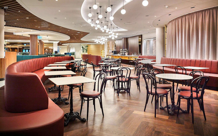 Vienna Lounge seating area with tables and chairs at Vienna Airport Terminal 1.