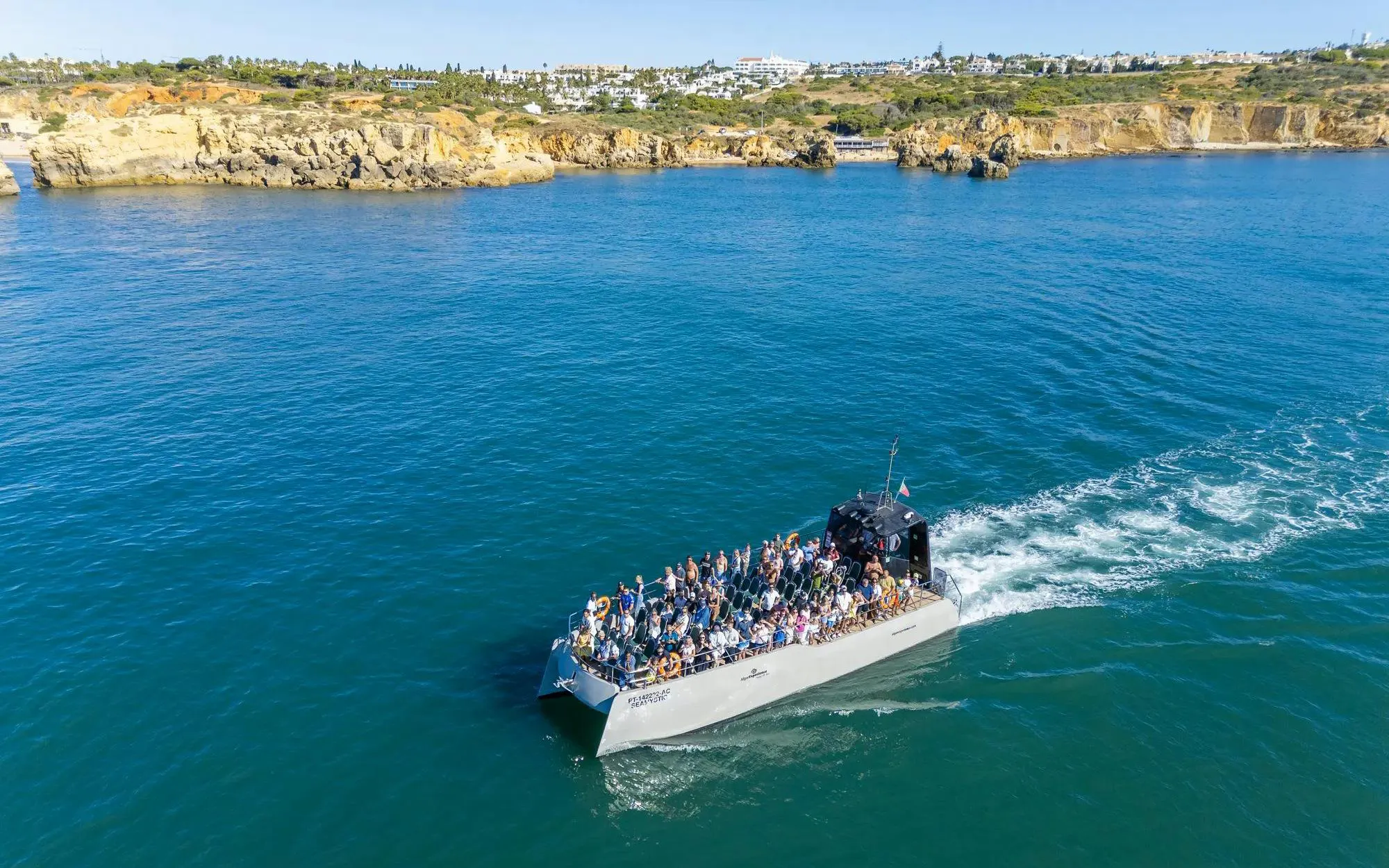 Tourists on a catamaran tour near Benagil Caves, Algarve coast.
