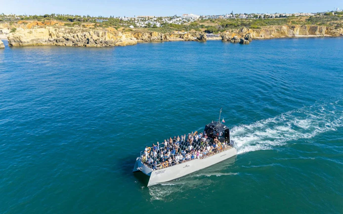 Tourists on a catamaran tour near Benagil Caves, Algarve coast.