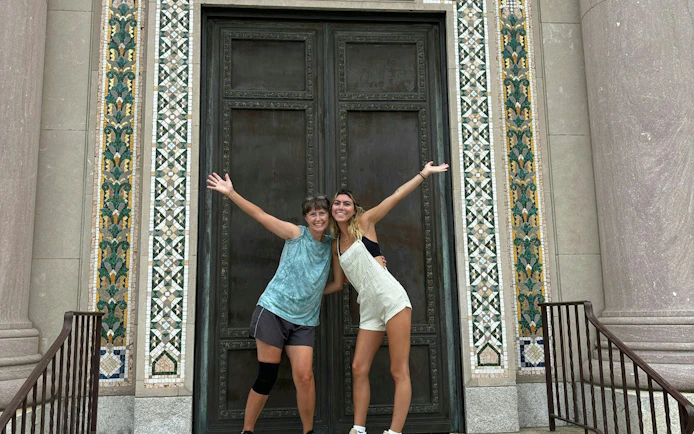 Two people posing in front of a historic building in Philadelphia during a self-guided city exploration game.