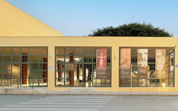 Heraklion Archaeological Museum entrance with banners displaying ancient artifacts.