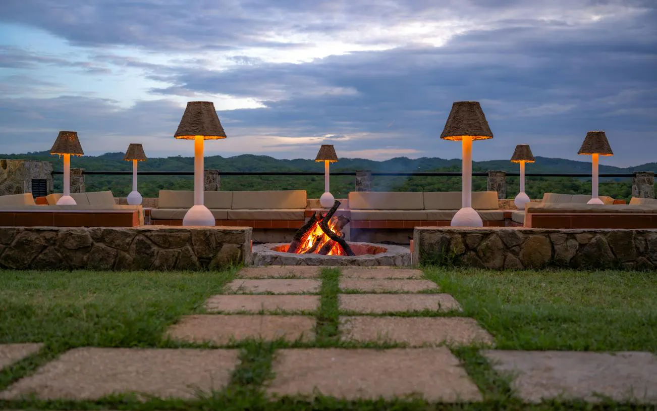 Outdoor seating area with fire pit and lamps at Mikumi National Park lodge, Zanzibar.