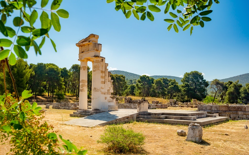 Ancient ruins at Epidaurus surrounded by trees, part of Nafplio-Mycenae-Epidaurus Day Tour.