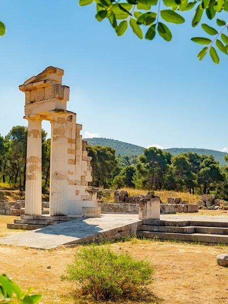 Ancient ruins at Epidaurus surrounded by trees, part of Nafplio-Mycenae-Epidaurus Day Tour.