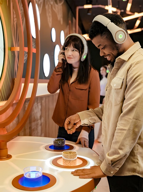 Tourists using audio guides at Pilsner Urquell The Original Beer Experience exhibit.