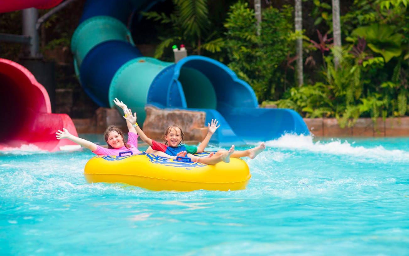 Children enjoying an inflatable tube ride at Amverton Riverine Splash water park.