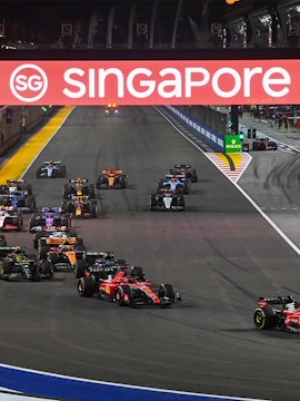 Formula 1 cars racing at night during the Singapore Grand Prix.