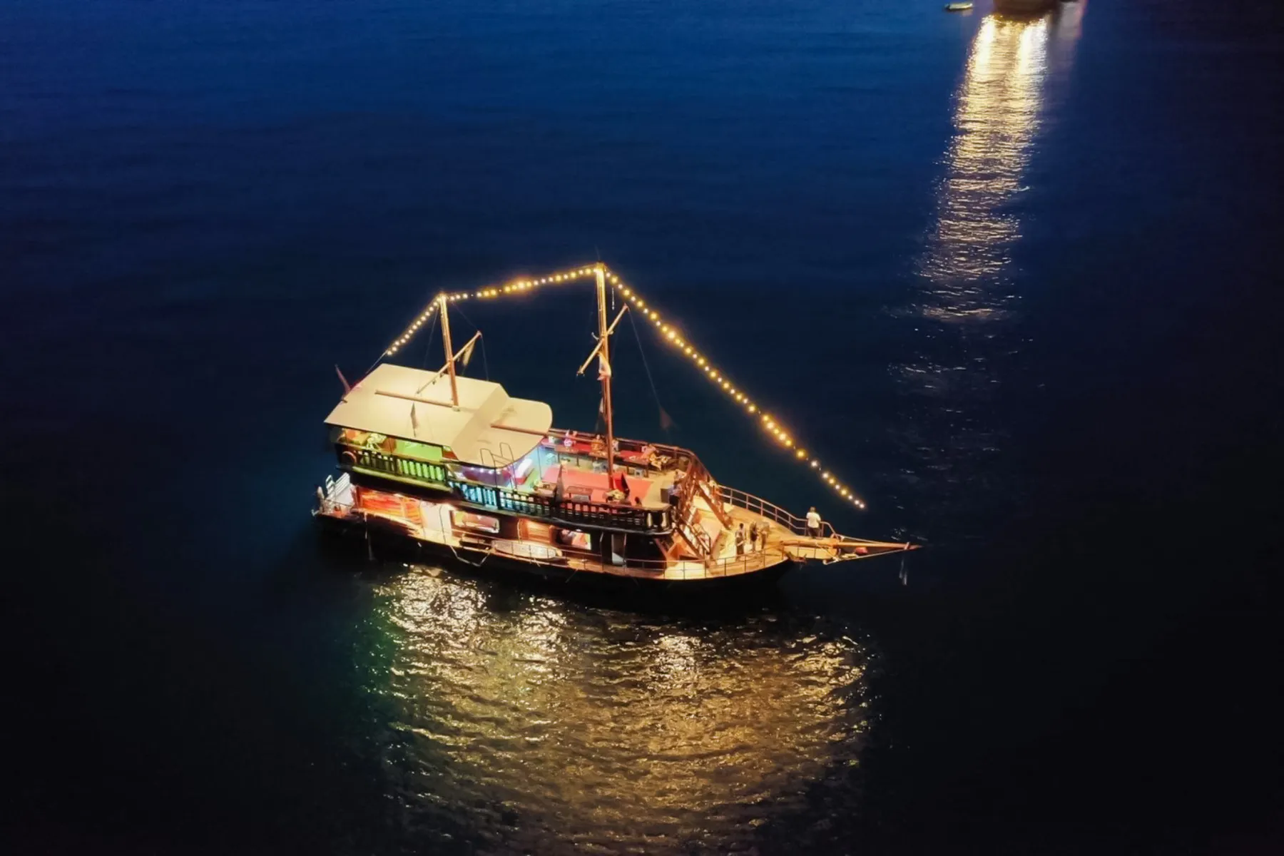 Pirate boat with lights on water during sunset near Koh Phi Phi, Krabi.