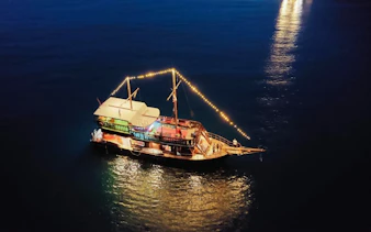 Pirate boat with lights on water during sunset near Koh Phi Phi, Krabi.