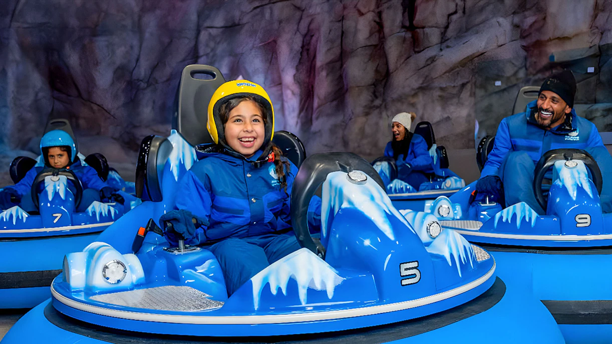 Children and adults enjoying bumper cars at Snow Abu Dhabi's Snow Park.