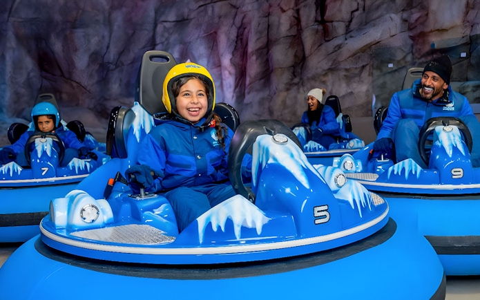 Children and adults enjoying bumper cars at Snow Abu Dhabi's Snow Park.