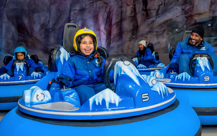 Children and adults enjoying bumper cars at Snow Abu Dhabi's Snow Park.