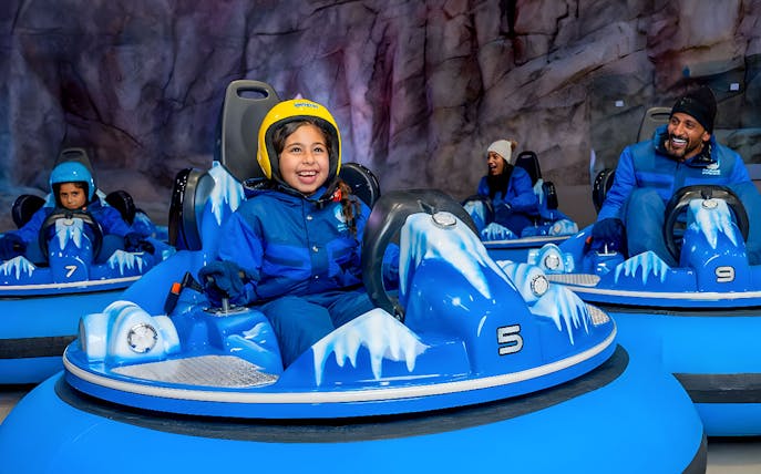 Children and adults enjoying bumper cars at Snow Abu Dhabi's Snow Park.