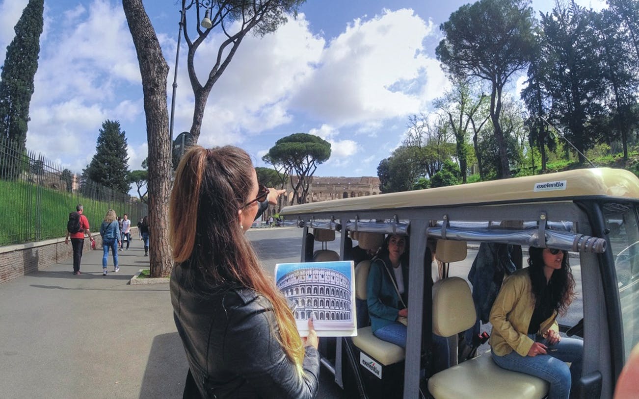 Tour guide pointing at Colosseum during Rome golf cart tour.