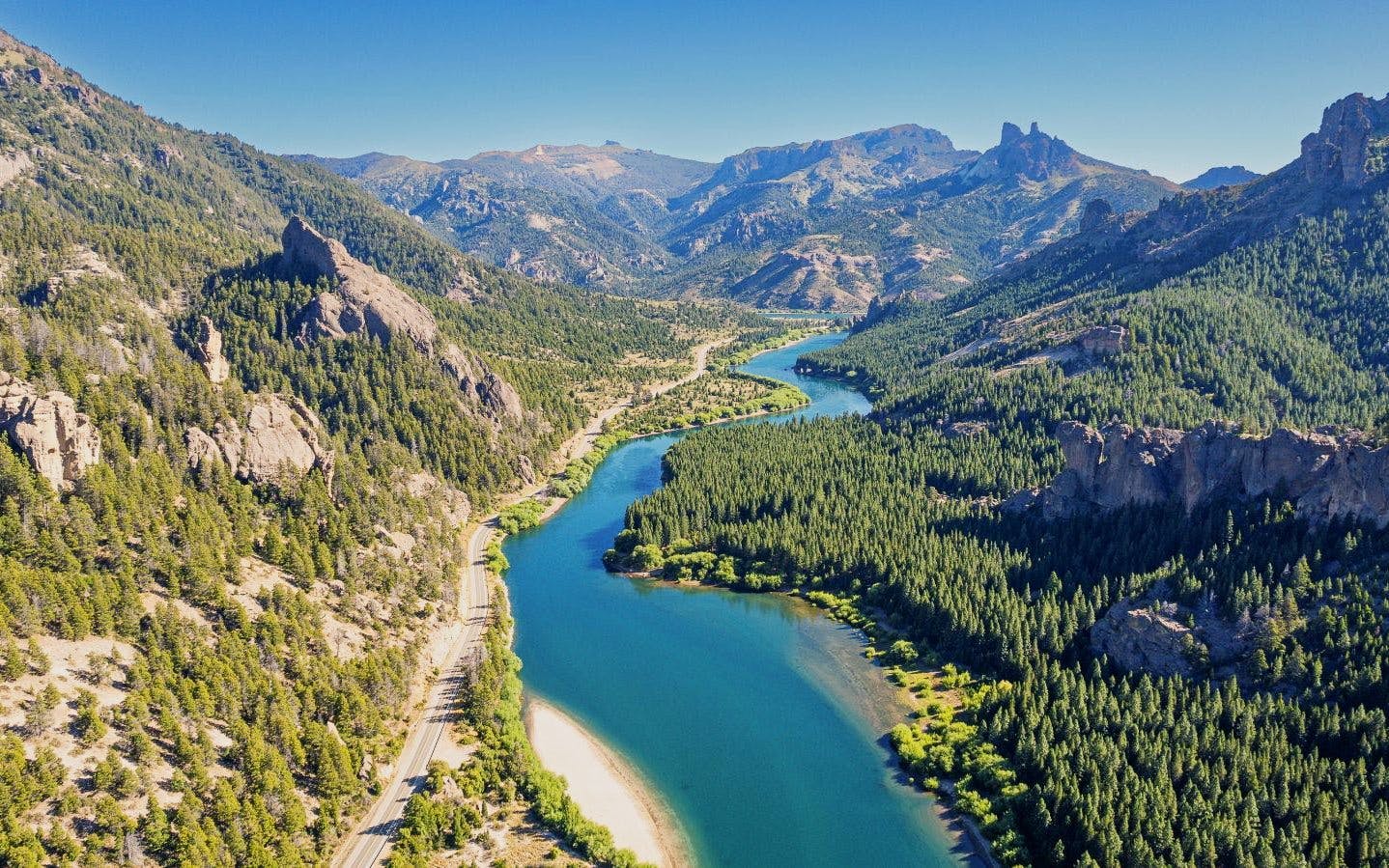 Aerial view of a river winding through a mountain valley in Patagonia.
