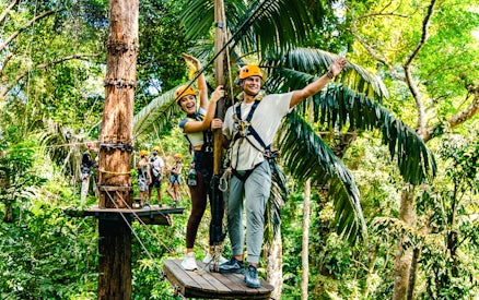 Participants on a zipline platform in a tropical forest, Flying Hanuman, Phuket.