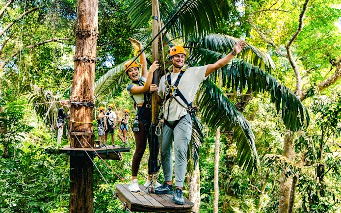 Participants on a zipline platform in a tropical forest, Flying Hanuman, Phuket.