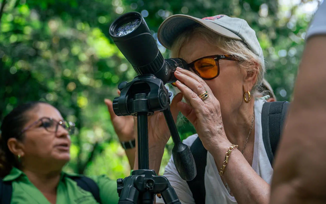 Tourist using a telescope for wildlife viewing in Manuel Antonio National Park.