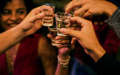 Friends toasting with shots during a night boat party.