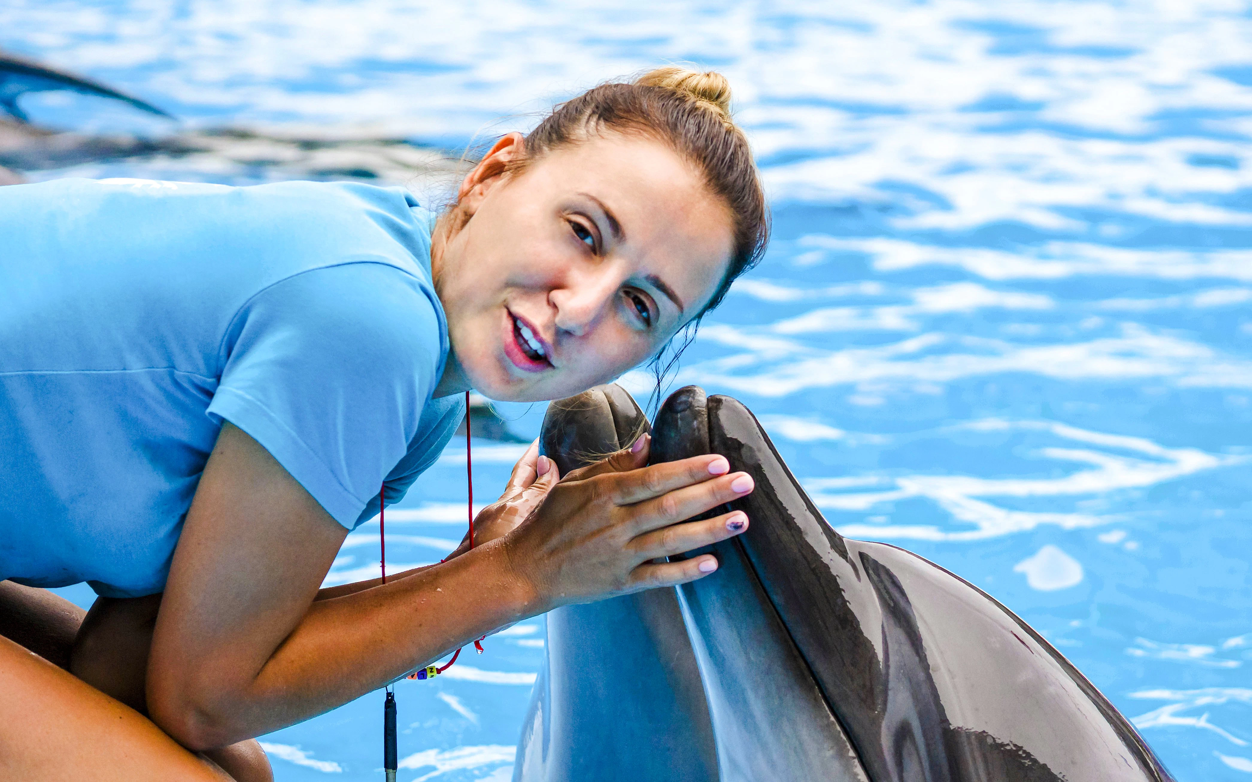 Woman interacting with dolphin at a marine show.