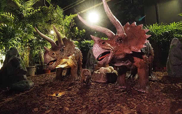 Dinosaurs at Dinoland Singapore with eggs in a jungle setting.