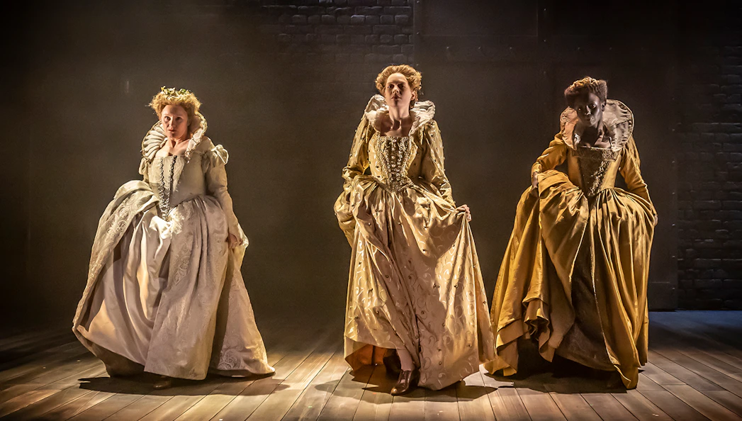 Three actors in period costumes performing on stage in Orlando theater production.