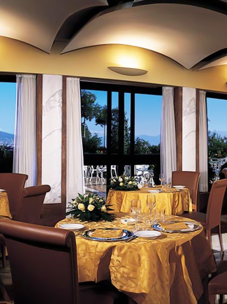 Rooftop terrace dining with view of Mount Vesuvius in Naples.