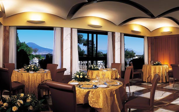 Rooftop terrace dining with view of Mount Vesuvius in Naples.