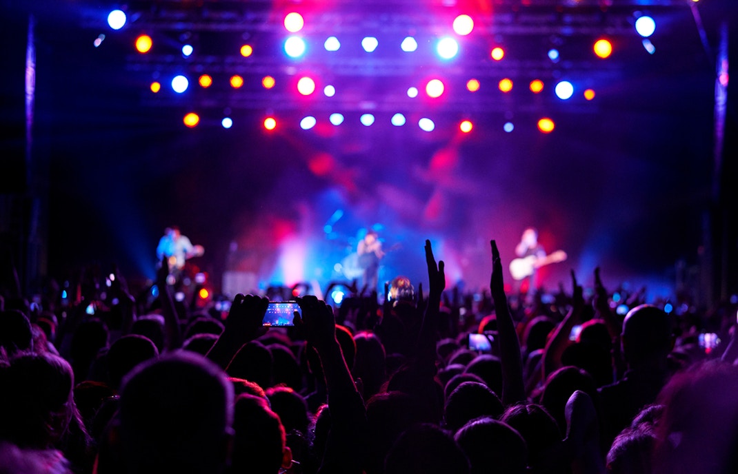 Crowd enjoying a live concert in Dubai with colorful stage lights.