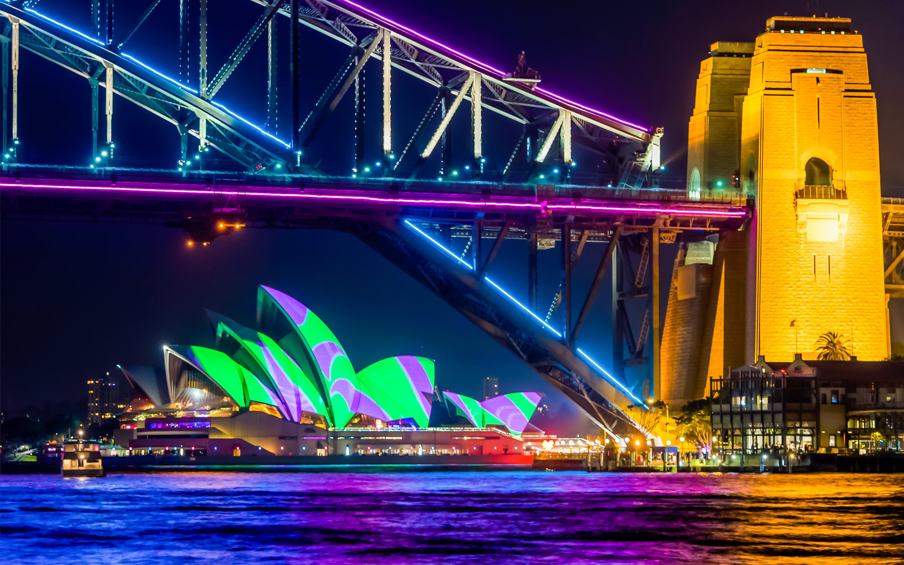 Sydney Harbour Bridge and Opera House illuminated during Vivid Sydney cruise.