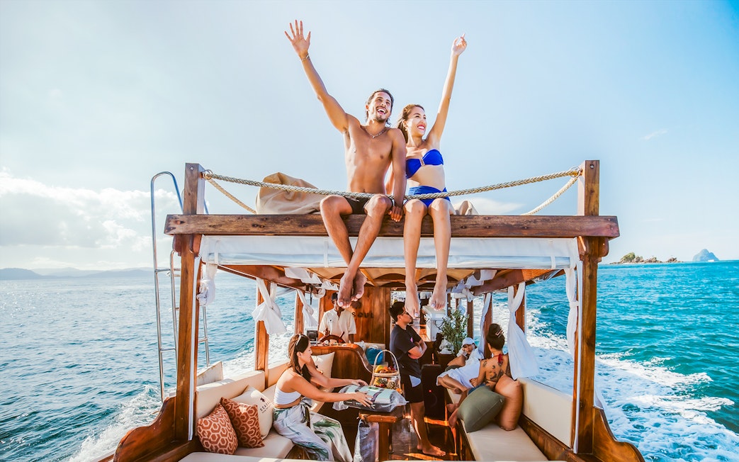 Luxury longtail boat cruise at sunset in Krabi with people relaxing.